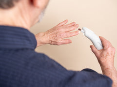 Person applying a small amount of cream to their hand with a beige background